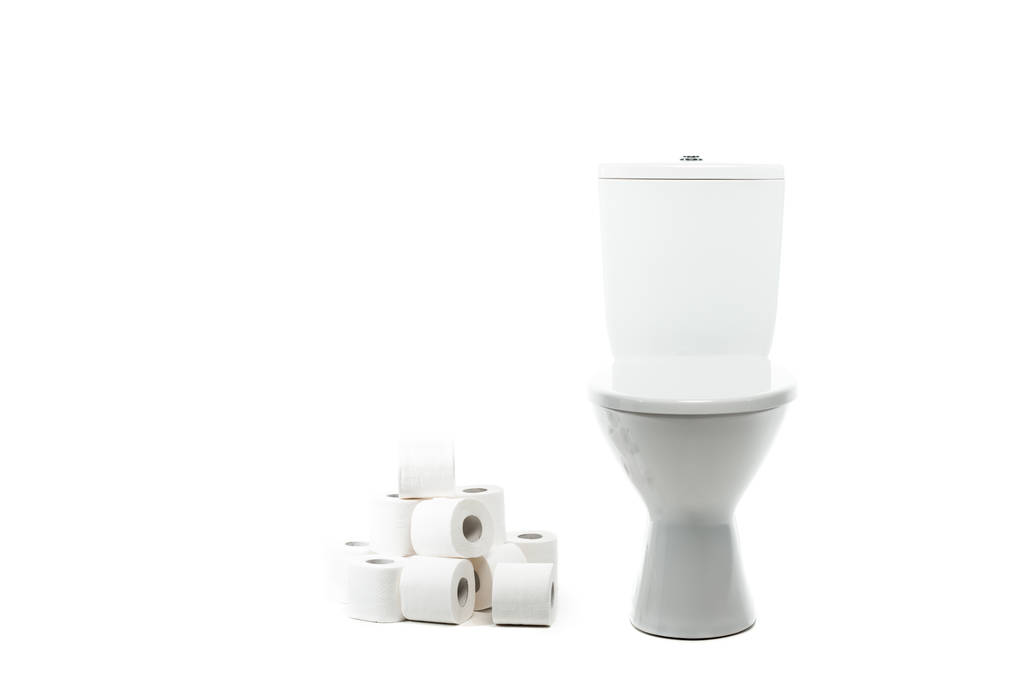 Keramik saubere Toilettenschüssel in der Nähe von Rollen Toilettenpapier isoliert auf weiß - Foto, Bild