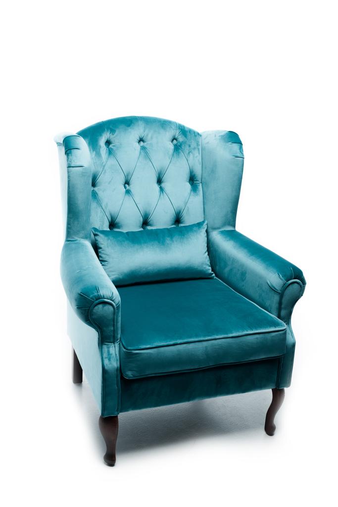 elegante sillón de terciopelo azul con almohada sobre blanco
 - Foto, imagen
