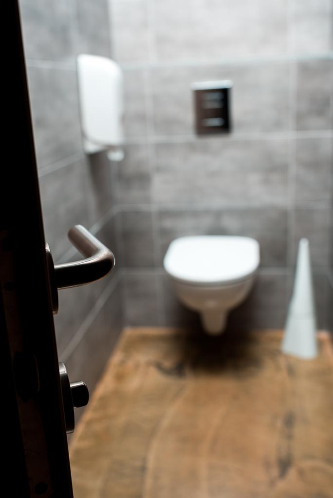 selektiver Fokus auf offene Tür und graue, moderne Toilette - Foto, Bild