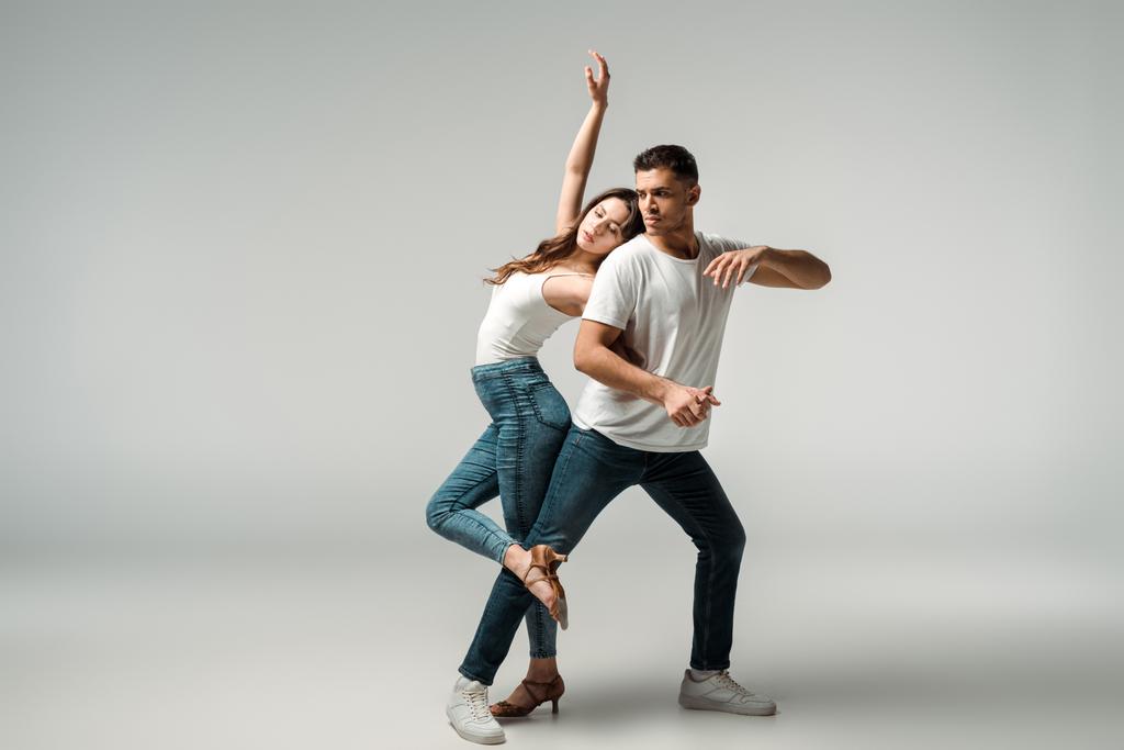 dancers with closed eyes dancing bachata on grey background  - Photo, Image