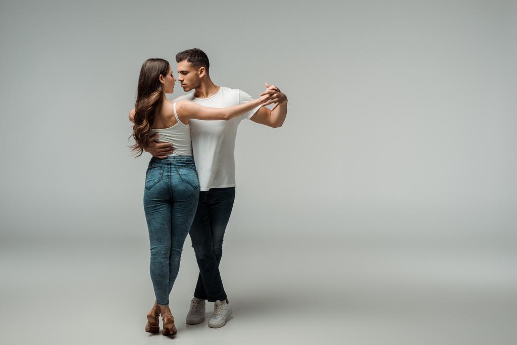 danseurs en jeans denim dansant bachata sur fond gris
  - Photo, image