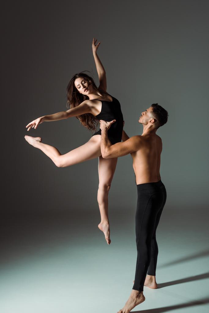 handsome and attractive dancers dancing contemporary on dark background  - Photo, Image