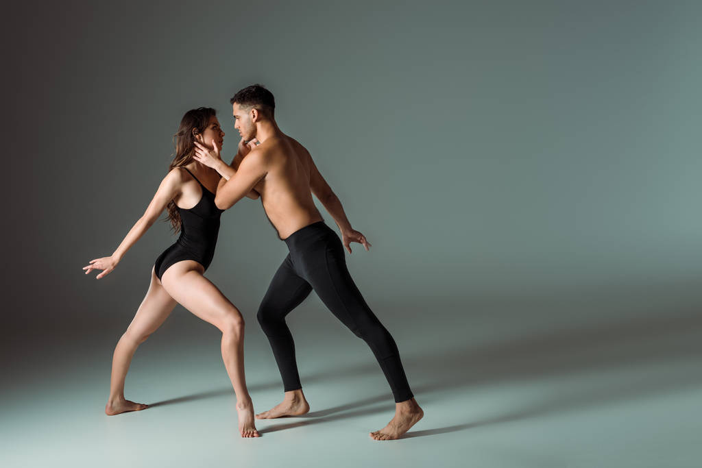 vue latérale de danseurs sexy dansant contemporain sur fond sombre
  - Photo, image