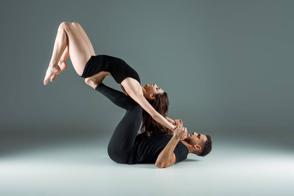 vue latérale de danseurs dansant contemporain sur fond sombre
  - Photo, image