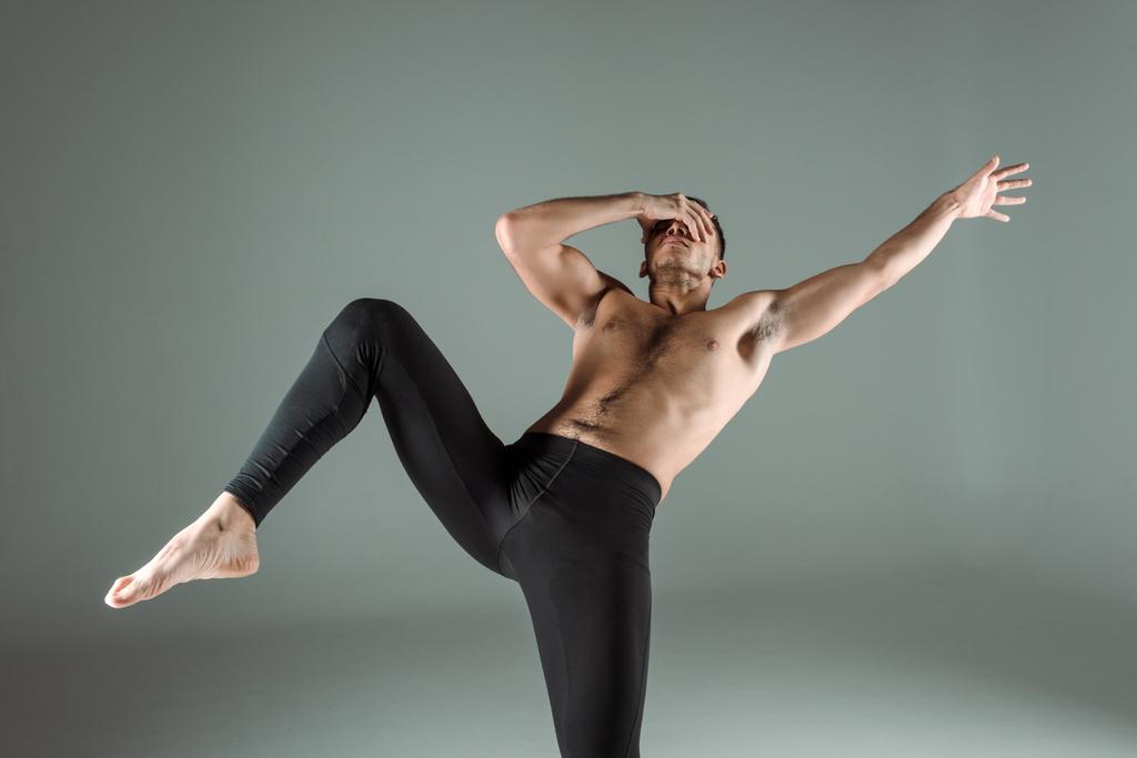 táncos fekete leggings tánc kortárs és homályos arc elszigetelt szürke - Fotó, kép