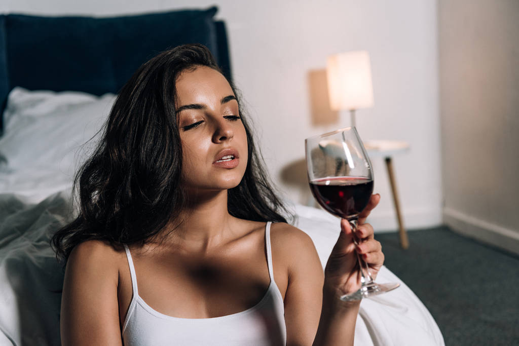 sensuelle, fille rêveuse tenant un verre de vin rouge dans la chambre
 - Photo, image