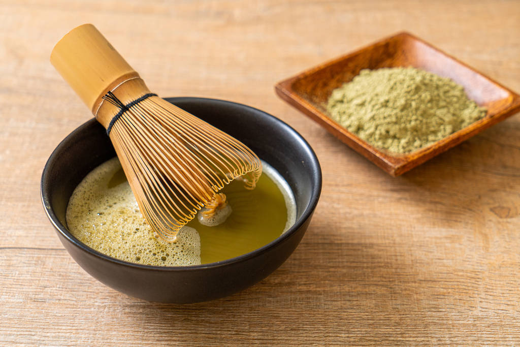 gorąca matcha zielona herbata filiżanka z zieloną herbatą w proszku i trzepaczki - Zdjęcie, obraz
