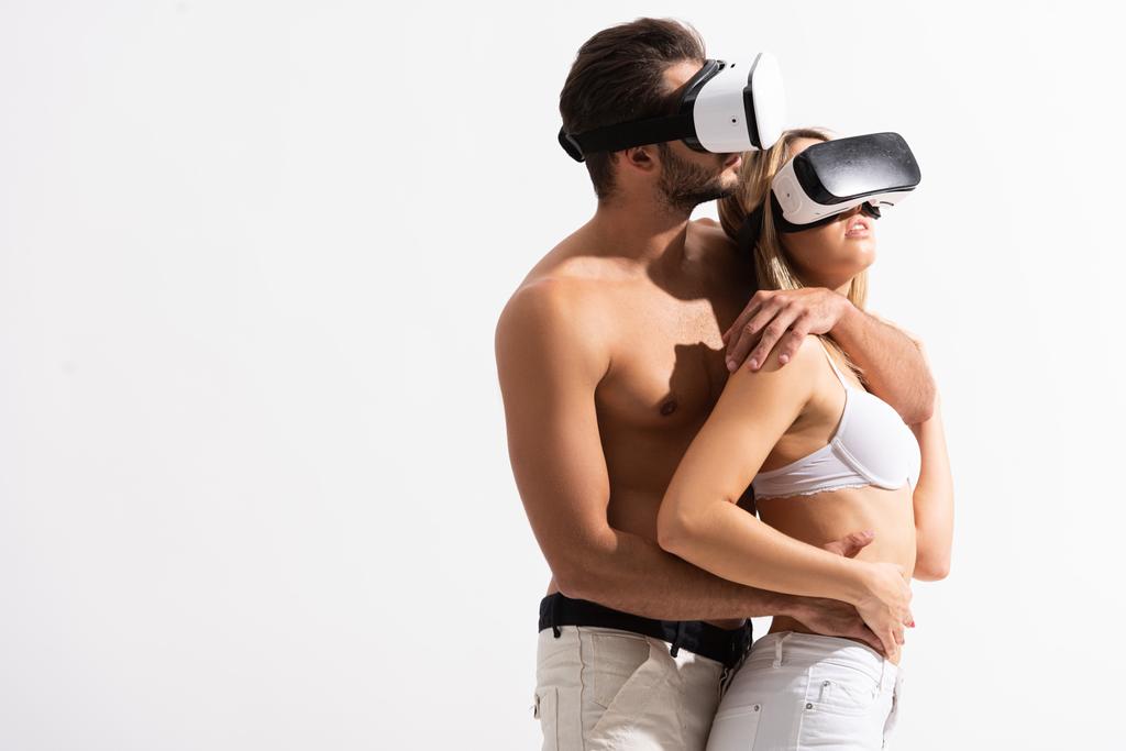 couple passionné dans les casques de réalité virtuelle câlins, isolé sur blanc
 - Photo, image