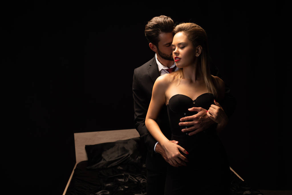 couple passionné debout près du lit dans la chambre noire
 - Photo, image