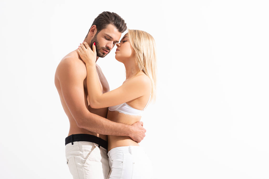 coppia sensuale in jeans bianchi che abbraccia isolato su bianco
 - Foto, immagini
