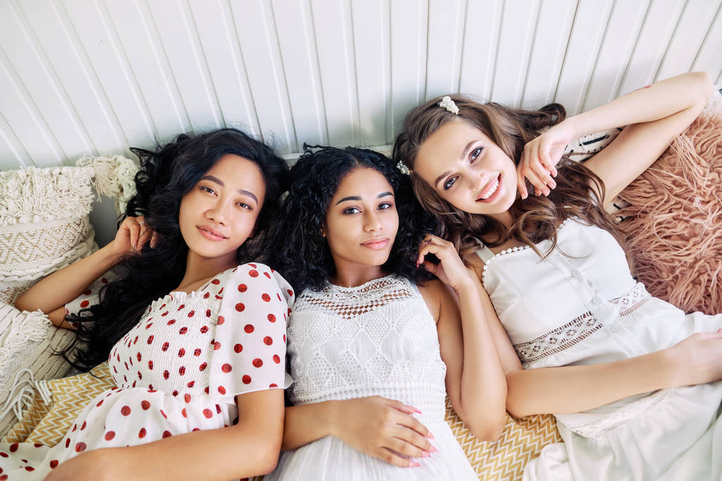 Χαμογελώντας γυναίκες χαλαρώνοντας και ξαπλωμένη στο κρεβάτι μέσα στο τροχόσπιτο. Γυναικεία φιλία και ομορφιά έννοια.  - Φωτογραφία, εικόνα