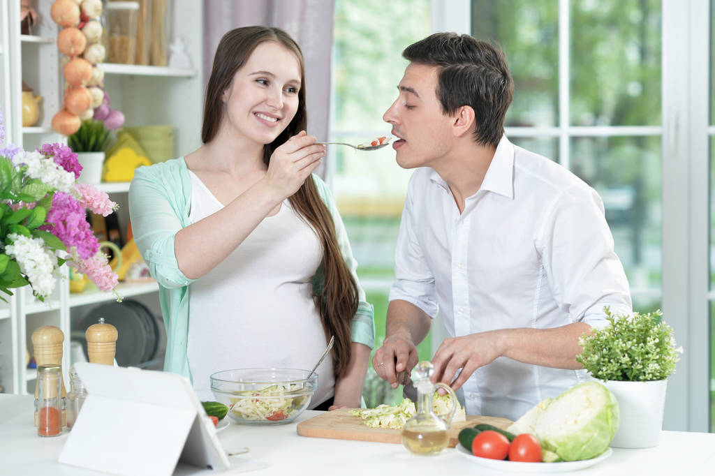 Feliz marido y mujer cocinando juntos en la cocina  - Foto, Imagen