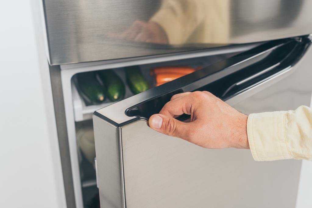 обрізаний вид людини відкриті двері холодильника
 - Фото, зображення