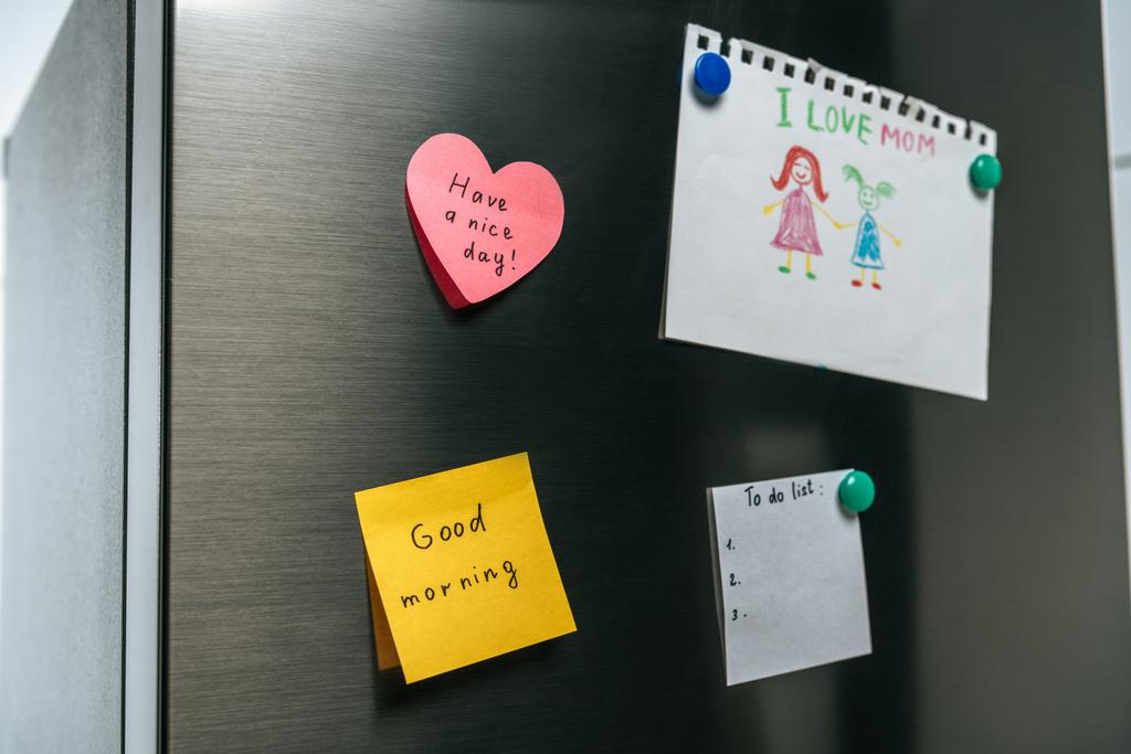 drawing of family and notes with wishes hanging on fridge - Photo, Image