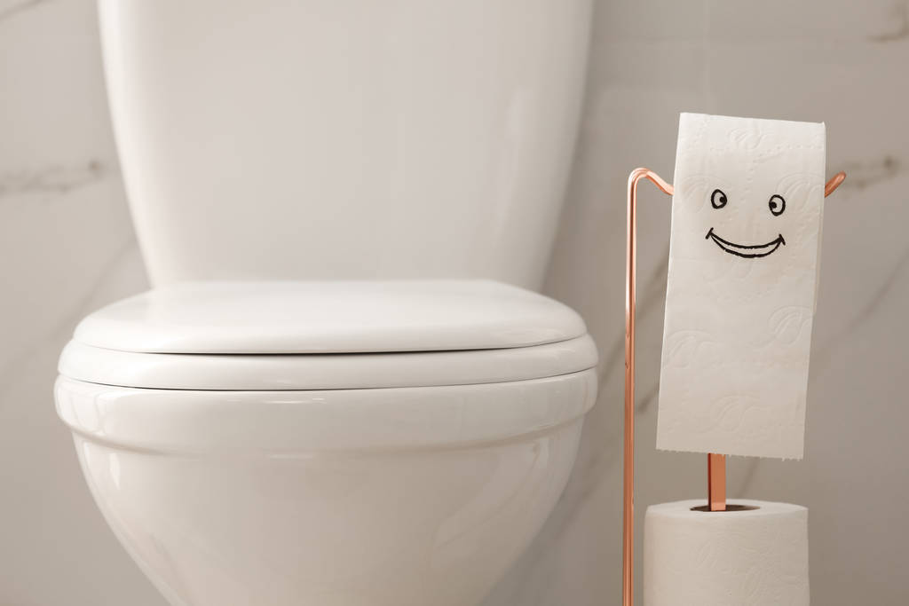 Современная унитаз и бумага с забавным лицом в ванной комнате
 - Фото, изображение