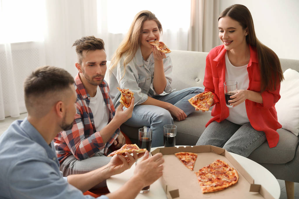 Ομάδα φίλων που τρώνε νόστιμη πίτσα στο σπίτι - Φωτογραφία, εικόνα