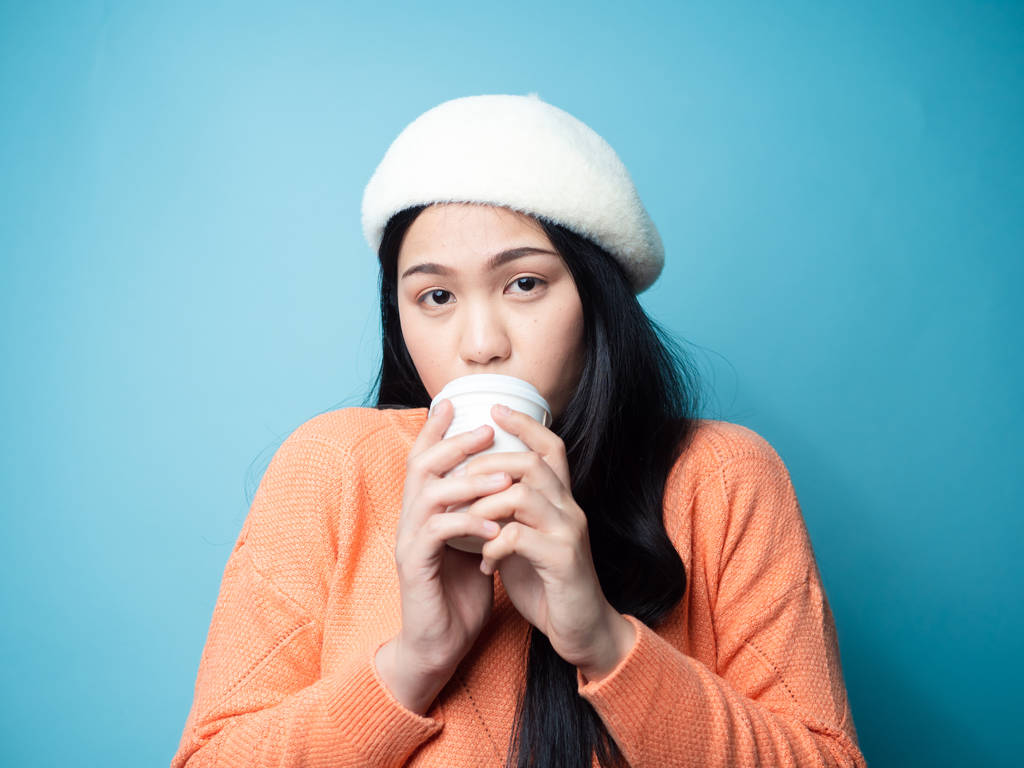 Happy Asian woman wearing sweater and drinking coffee take away  - Valokuva, kuva