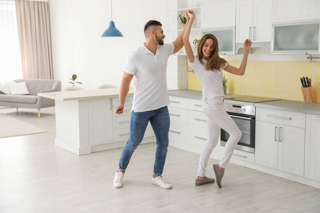 Beau jeune couple dansant dans la cuisine à la maison
 - Photo, image