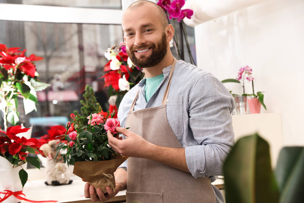 Szakmai férfi virágárus kötényben a munkahelyen - Fotó, kép