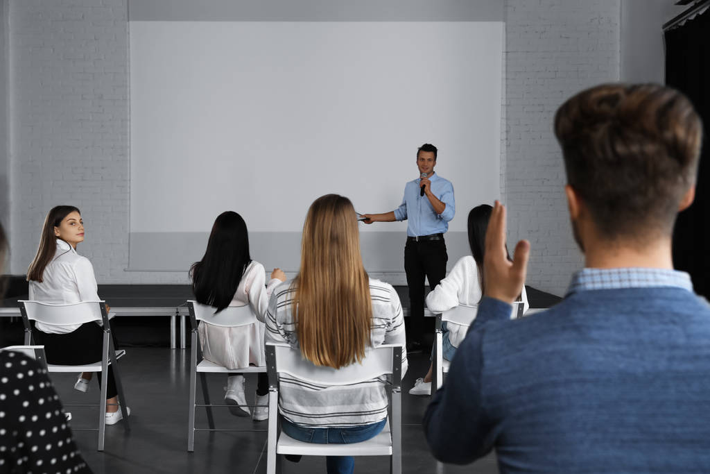 Treinador de negócios masculino dando palestra na sala de conferências com tela de projeção
 - Foto, Imagem