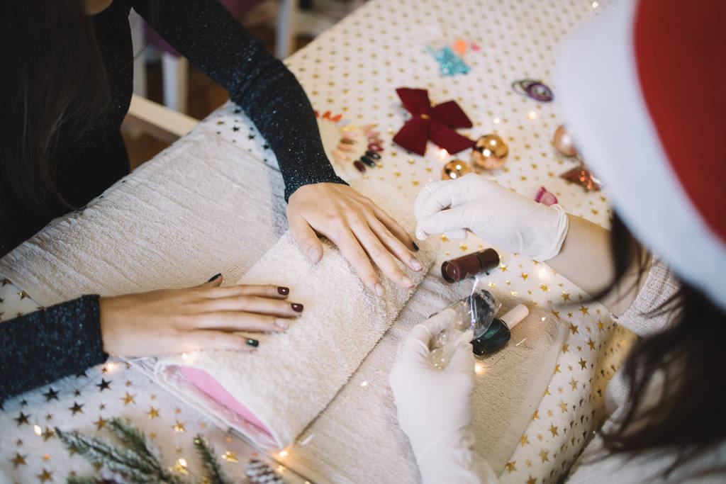Manicurist pouring white brocade over womans nails - Photo, Image