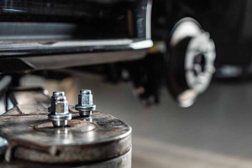 селективный фокус металлических винтовых гаек на автомобильном подъемнике
 - Фото, изображение
