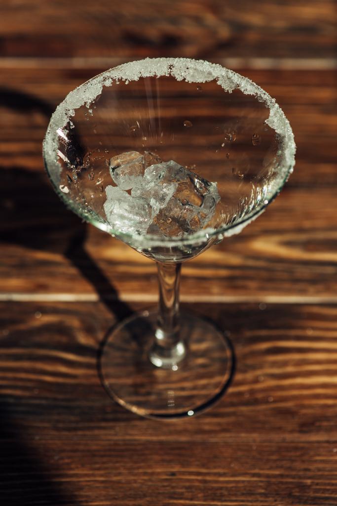 Martini sklo s ledem zdobené cukrem na dřevěném povrchu na slunci - Fotografie, Obrázek