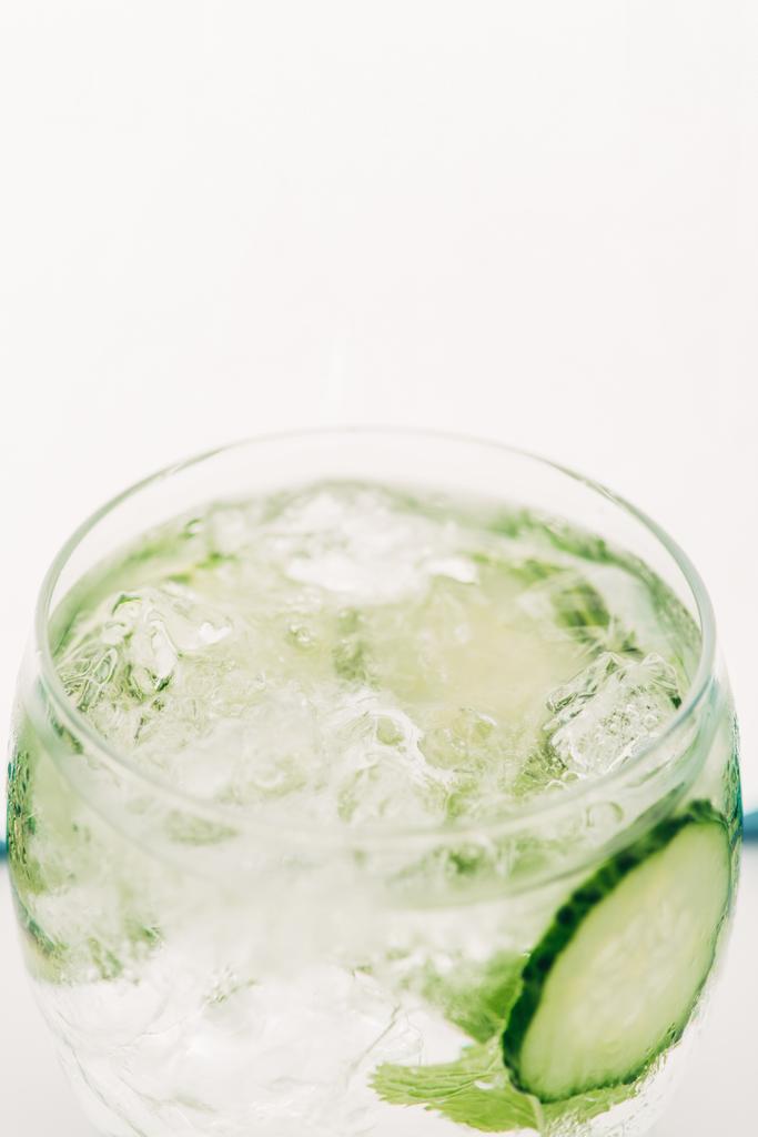 zblízka pohled na čerstvý gin s tonikem s okurkovými plátky izolovanými na bílém - Fotografie, Obrázek