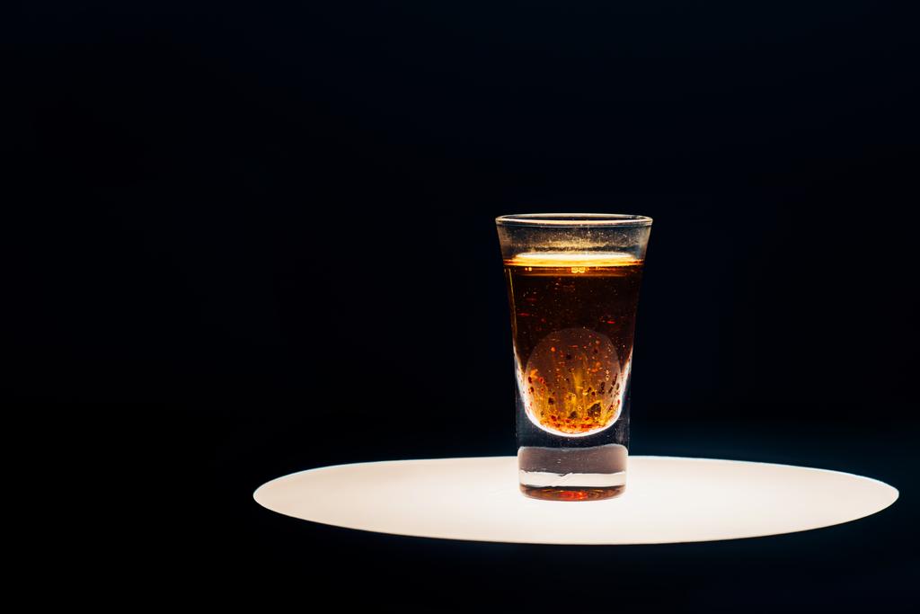 алкоголь выстрел на освещенном круге изолированы на черный
 - Фото, изображение