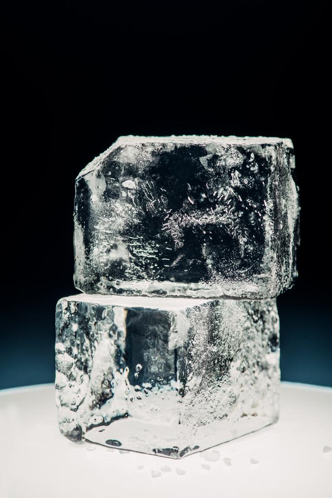 vista de cerca de cubos de hielo cuadrados en círculo iluminado aislado en negro
 - Foto, imagen