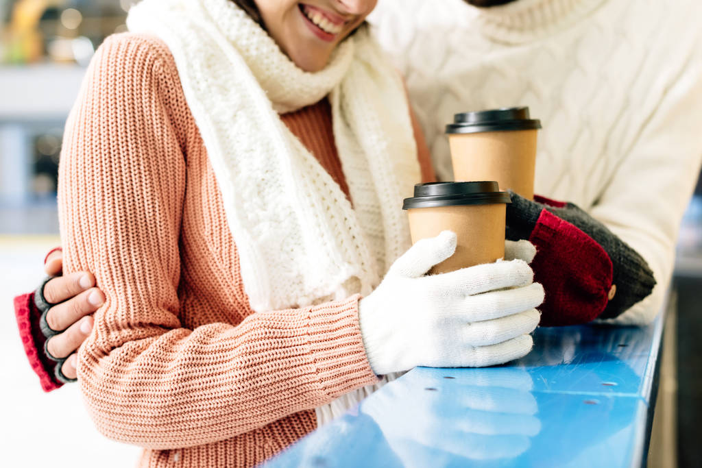 ハッピーカップルがコーヒーを飲みながらスケートリンクに行き - 写真・画像