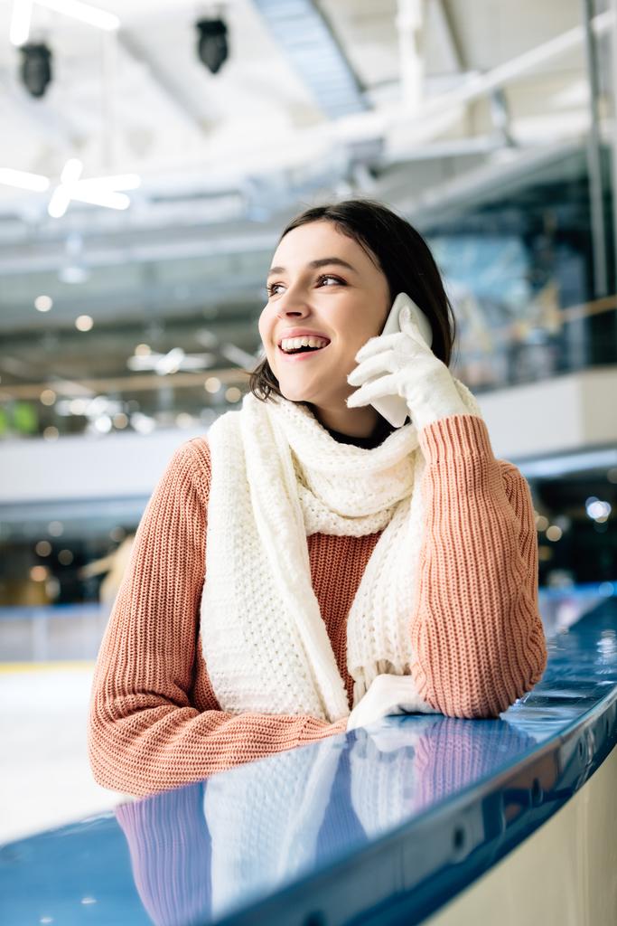 счастливая молодая женщина разговаривает на смартфоне на катке
 - Фото, изображение