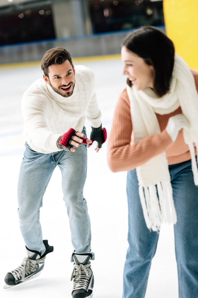 animado jovem casal se divertindo enquanto patina no ringue
   - Foto, Imagem