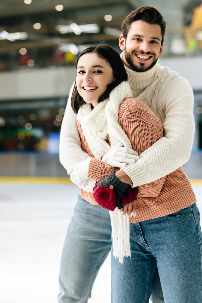 θετική αγκαλιά ζευγάρι και τη διασκέδαση στο παγοδρόμιο   - Φωτογραφία, εικόνα