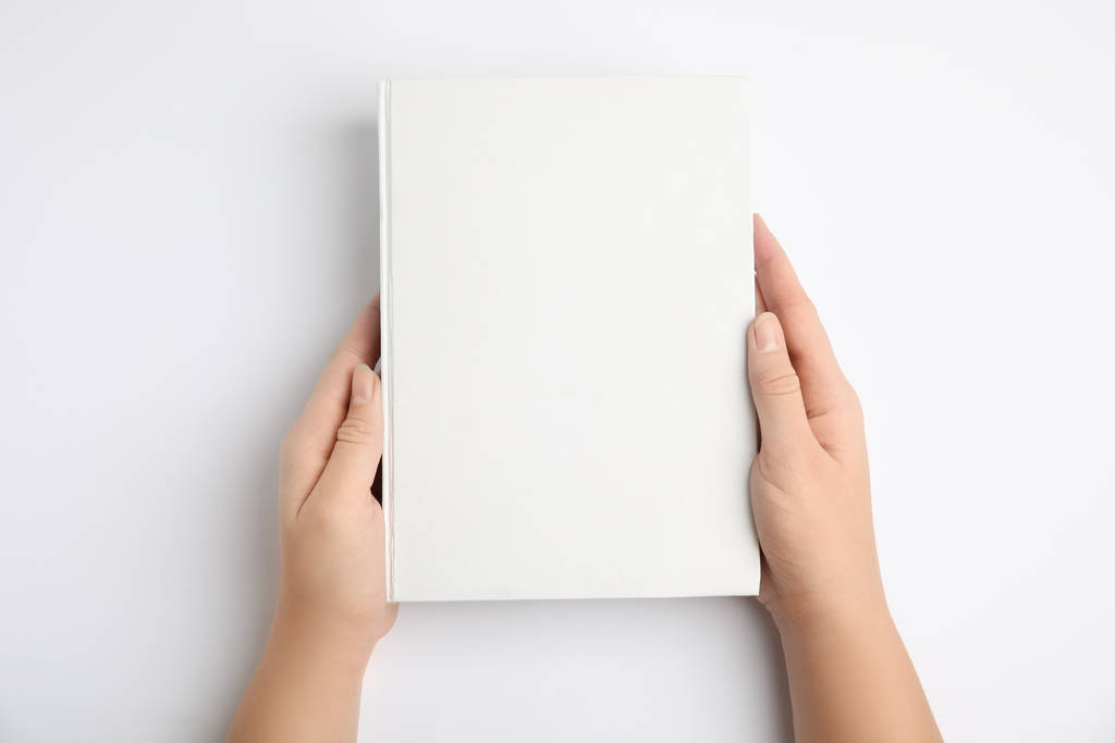 Nő holding book with blank cover on white background, felső nézet - Fotó, kép