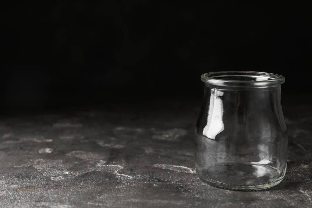 Frasco de vidrio vacío sobre mesa de piedra gris, espacio para texto
 - Foto, imagen