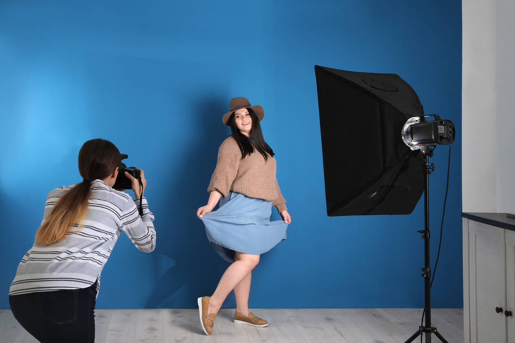 Fotógrafo tomando fotos de una mujer con sobrepeso en el estudio. Modelo de tamaño más
 - Foto, imagen