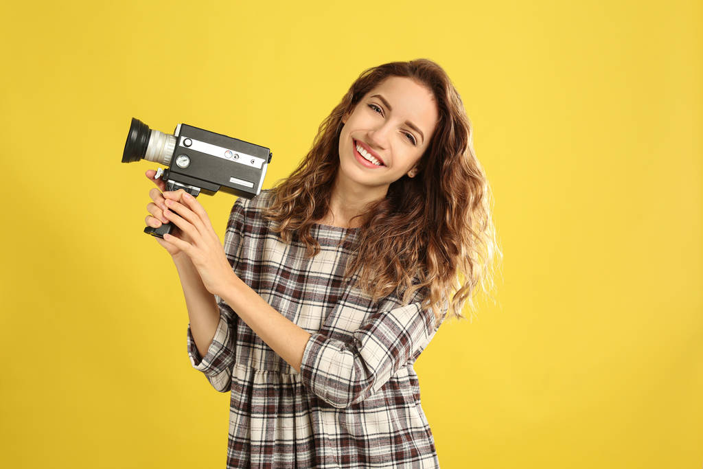 Bella giovane donna con videocamera vintage su retro giallogr
 - Foto, immagini