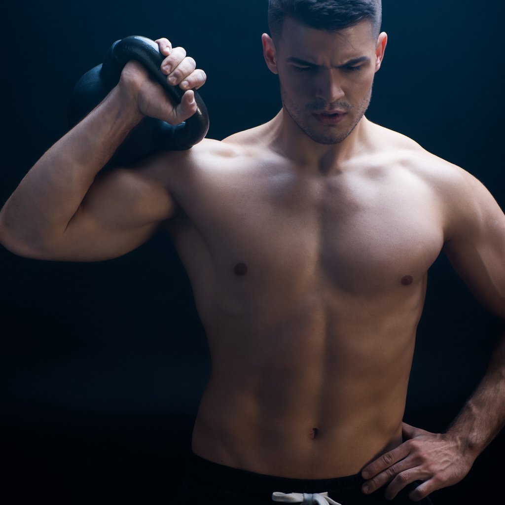 sexy musculoso culturista con torso desnudo extirpando con kettlebell sobre fondo negro
 - Foto, Imagen