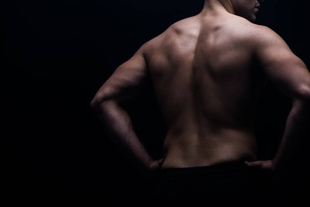 partial view of sexy bodybuilder with muscular back posing isolated on black - Photo, Image