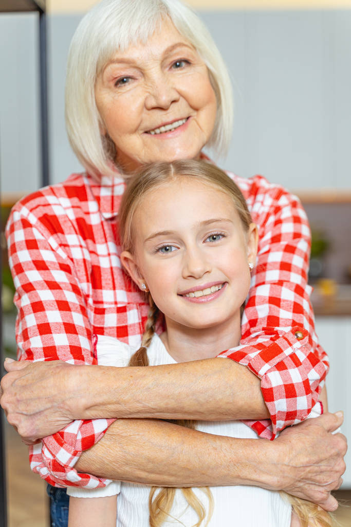 Kochająca starsza pani przytulająca swoją piękną wnuczkę - Zdjęcie, obraz