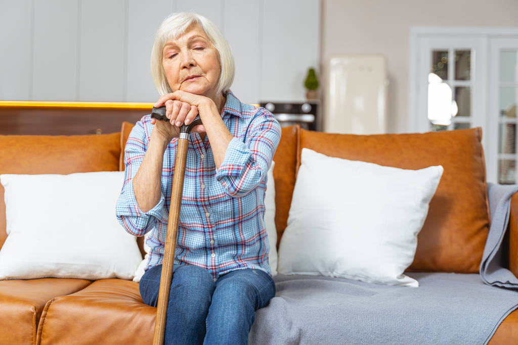 Senior lady sleeping with a walking stick - Photo, Image