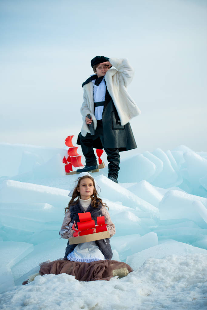 crianças brincando no iceberg com brinquedos de navio de madeira no fundo de inverno
 - Foto, Imagem