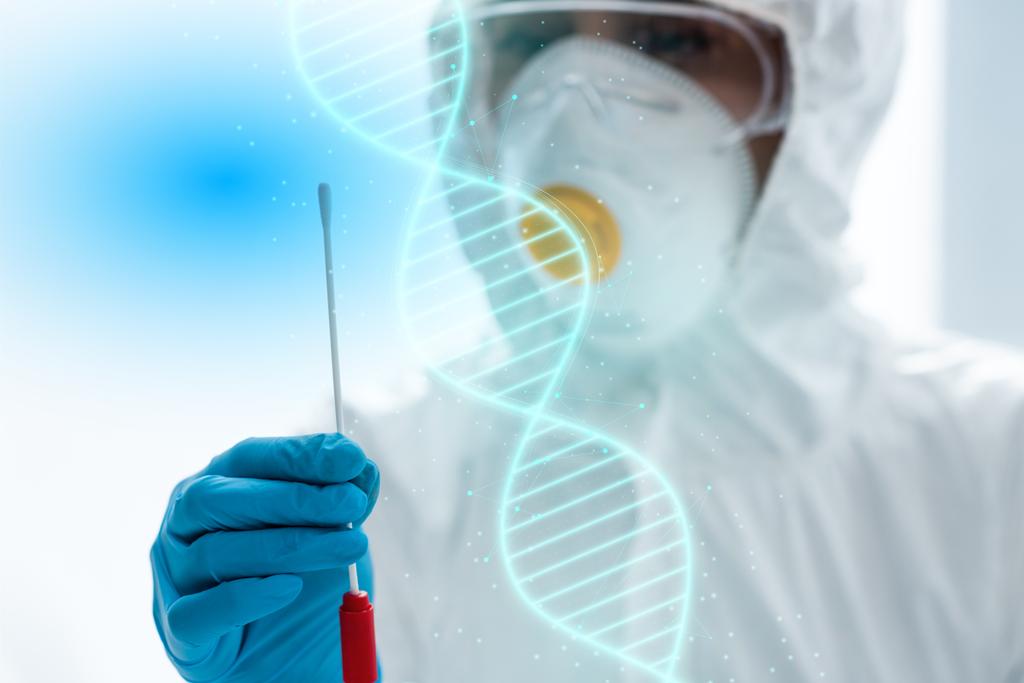 enfoque selectivo del científico haciendo la prueba de ADN y de pie cerca de la ilustración
  - Foto, Imagen