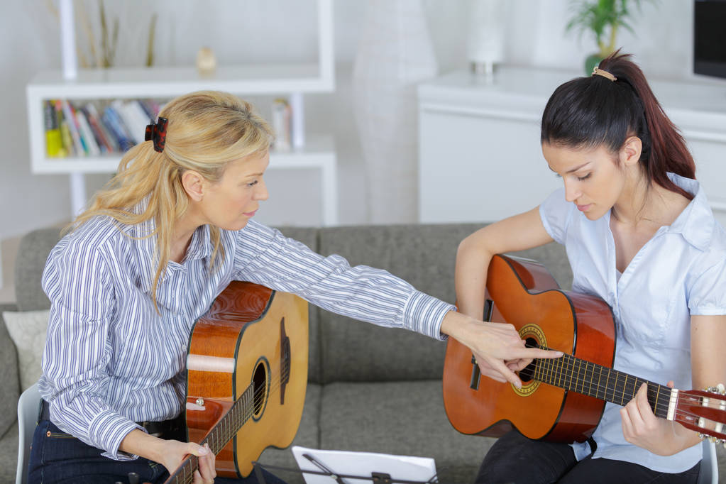 νεαρή γυναίκα Μαθαίνοντας να παίξει κιθάρα - Φωτογραφία, εικόνα