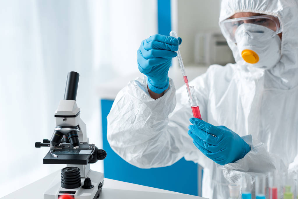 naukowiec w kombinezonie ochronnym i rękawiczkach lateksowych wykonujący test DNA  - Zdjęcie, obraz
