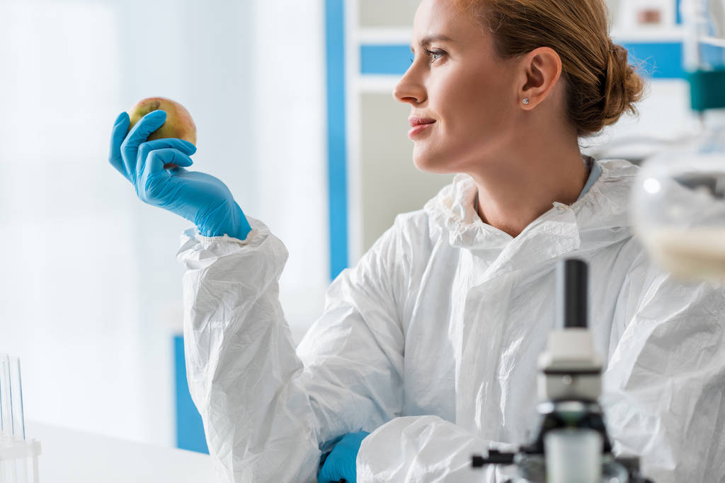 selective focus of biologist holding whole apple in lab  - Photo, Image
