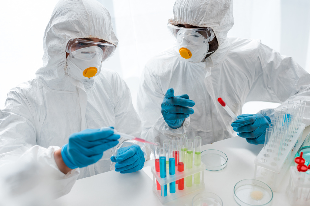 científicos multiculturales en trajes de protección haciendo prueba de ADN en el laboratorio
  - Foto, imagen