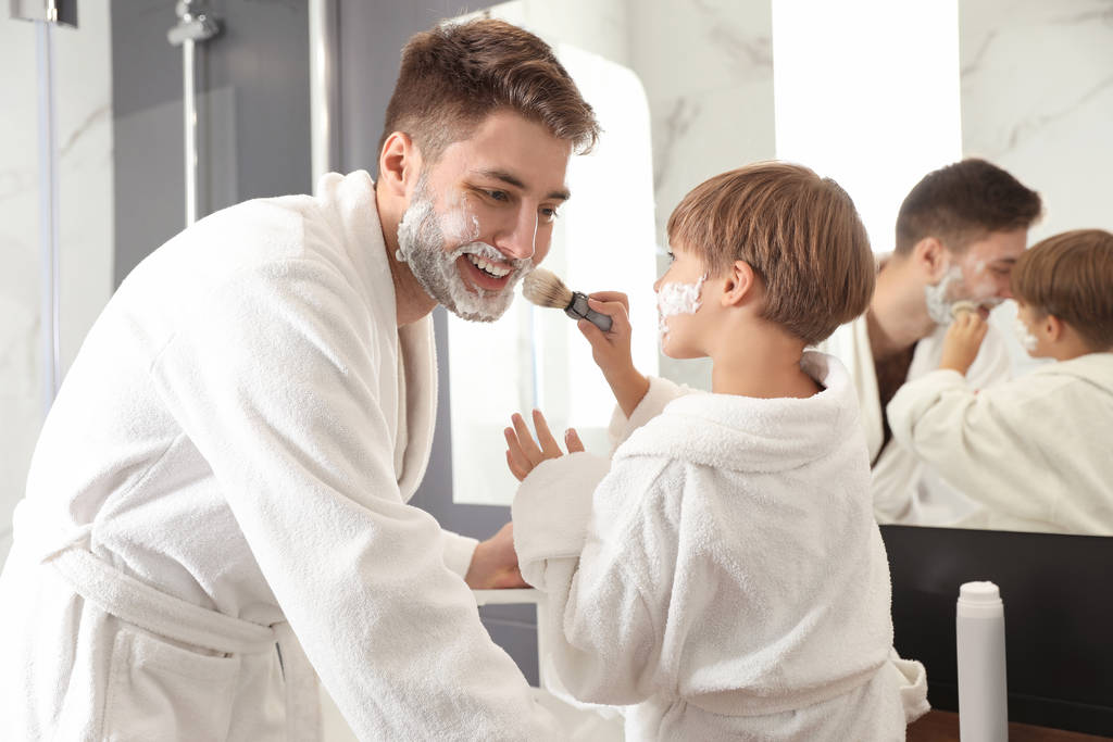 Papa und Sohn mit Rasierschaum im Gesicht und Spaß im Bad - Foto, Bild