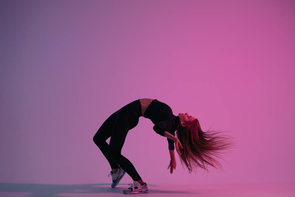 Schöne, kreative Tänzerin posiert im Studio vor buntem Hintergrund. junge charismatische Frau tanzt - Foto, Bild